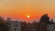 The sun is low in the sky over the watr in Tel Aviv.